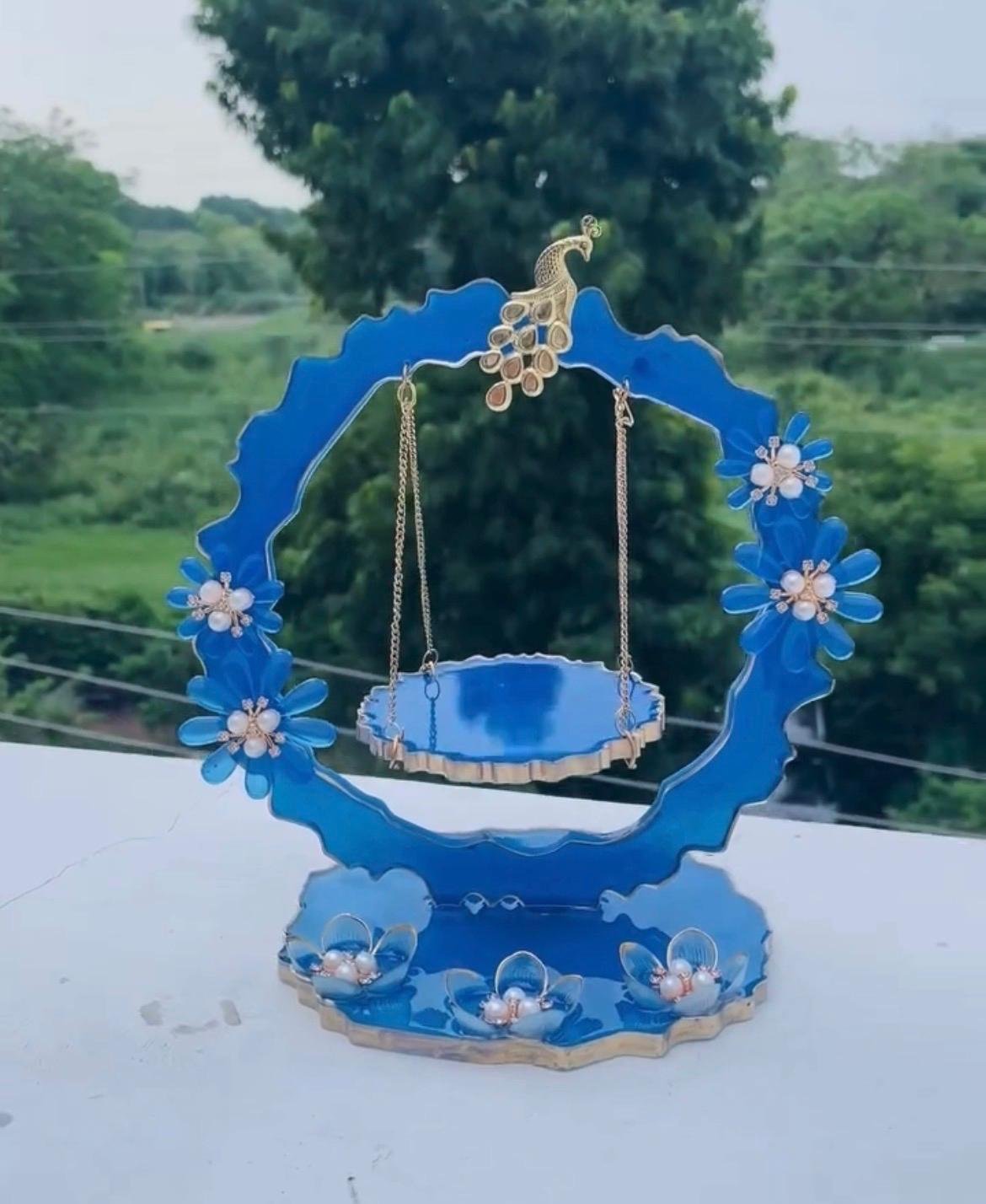 Blue handcrafted resin Laddu Gopal Ji jhula with peacock and floral decorations