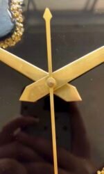 Close-up of gold clock hands on luxury resin wall clock