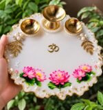 Handcrafted lotus resin pooja thali with pink flowers and brass diyas