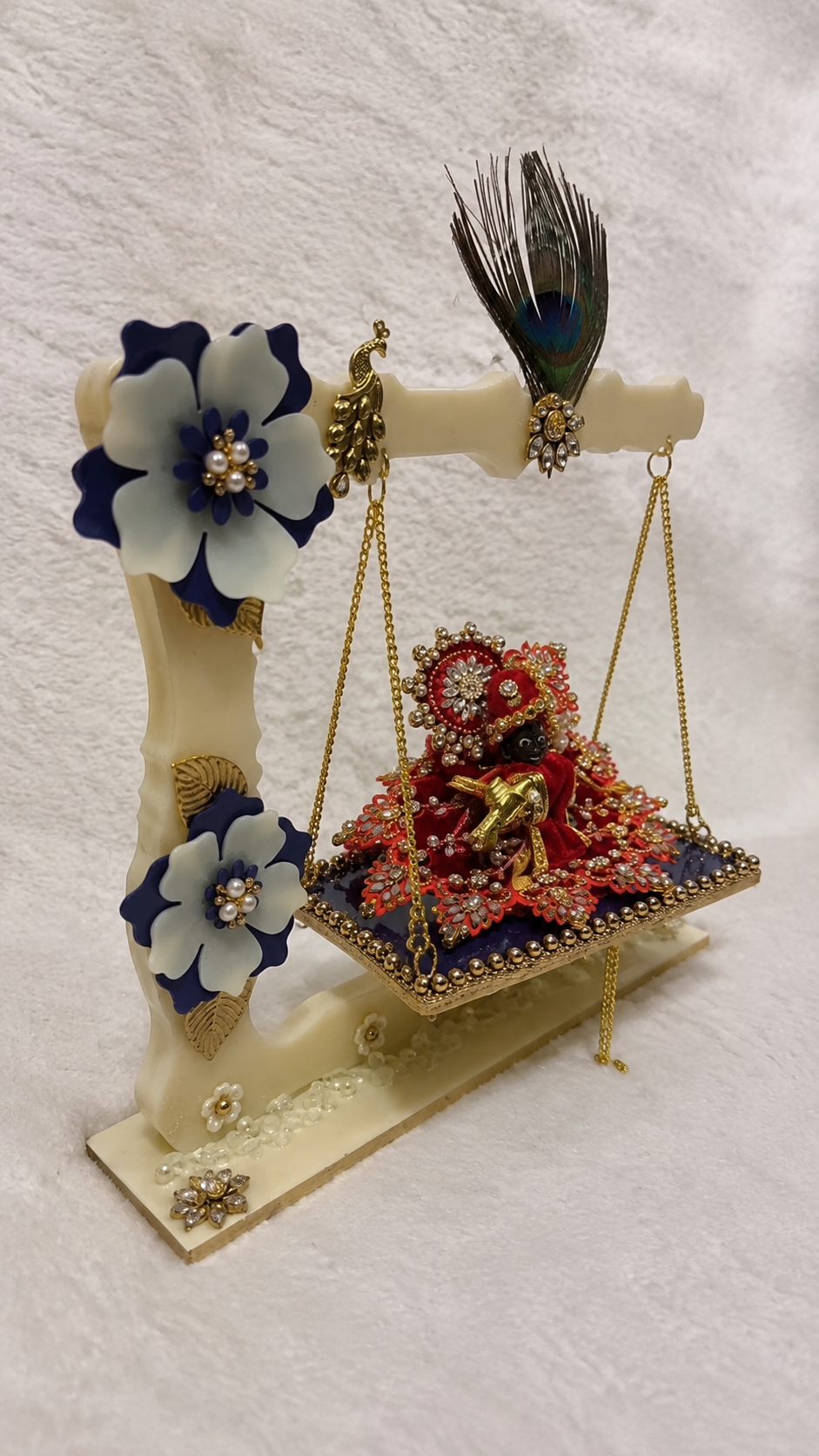 Angled view of handcrafted Krishna jhula with Laddu Gopal Ji, peacock feather and floral decorations