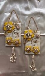 Handmade resin Shubh Labh wall hanging set with Lord Ganesha, yellow floral design and pearl tassels for home entrance decoration.
