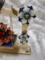 Close-up of blue and white floral decorations and peacock embellishments on Laddu Gopal Ji jhula